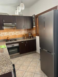 a kitchen with a stainless steel refrigerator and brown cabinets at Apartement cabo in Tétouan