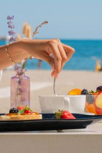 a person eating food on a table at the beach at Hotel Liberty Beach - Parking & Beach in Riccione