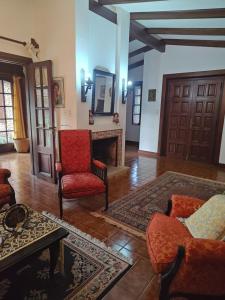 a living room with a red chair and a fireplace at Lo de Delia in City Bell