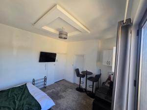 a bedroom with a bed and a table and chairs at Encliffe apartment in Nether Edge
