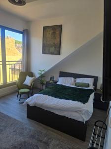 a bedroom with a large bed and a balcony at Encliffe apartment in Nether Edge