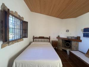 a bedroom with a bed in a room with a fireplace at Refugio de Montaña "El Caroche" Alojamiento entero in Enguera