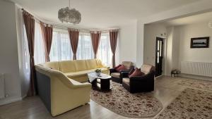 a living room with a couch and two chairs at Villa Odorica in Gura Humorului
