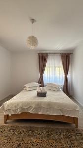 a bedroom with a large bed with a window at Villa Odorica in Gura Humorului