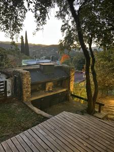 a house with a tree and a wooden deck at Loft de Montaña in Río Ceballos