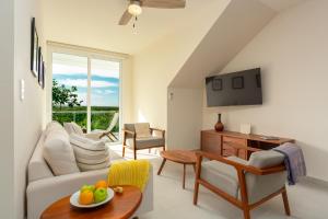 a living room with a couch and a table at Luxurious penthouse by the beach in Akumal