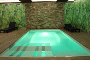 a swimming pool with two chairs in a room at Hotel Vilobi in Vilobí d'Onyar