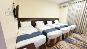a row of four beds in a room at Sama Al Bayt in Mecca