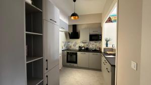 a kitchen with white cabinets and a stove top oven at Maison Diderot in Langres