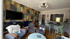 a living room with a tv and chairs and a table at Maison Diderot in Langres