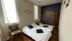 a bedroom with a bed and a chair in it at Maison Diderot in Langres