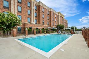 a swimming pool in front of a brick building at Hampton Inn and Suites Swansboro Near Camp Lejeune in Swansboro