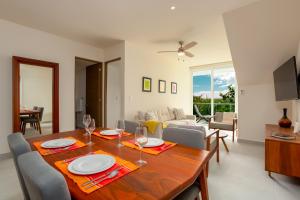 a dining room and living room with a table and chairs at Luxurious penthouse by the beach in Akumal