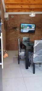 a dining room with a table and chairs and a tv at lo de la Gri in El Volcán +1 photo