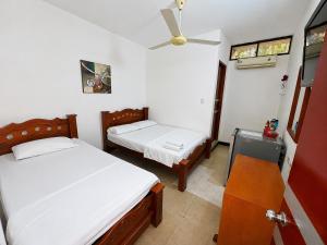 a bedroom with two beds and a ceiling fan at Hotel MAR&ANA in El Banco