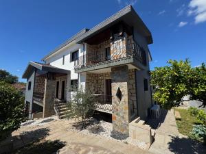 a house with a balcony on a sunny day at Alojamentos do Conde in Ponte de Lima