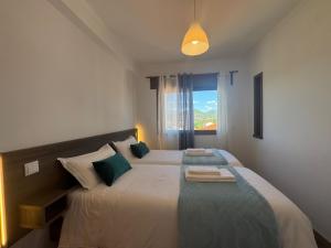 a bedroom with a large bed with a window at Alojamentos do Conde in Ponte de Lima