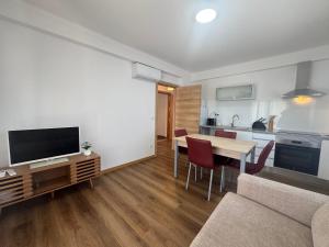 a living room with a table and a kitchen at Alojamentos do Conde in Ponte de Lima