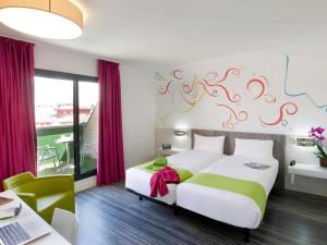 a bedroom with a bed and a desk with a laptop at Ibis Styles Madrid Prado in Madrid +94 photos
