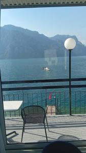 a chair sitting on a balcony overlooking the water at Villa Monica in Malcesine