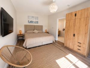 a bedroom with a bed and a television and a chair at Sea Mourne View in Carlingford +16 photos