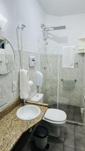 a bathroom with a toilet and a sink and a shower at Pousada Jara in Conservatória
