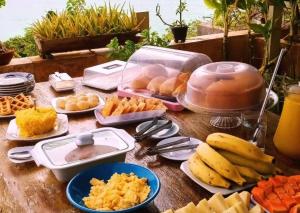 a table topped with plates of food and fruit at Pousada Azul Marinho in Canoa Quebrada