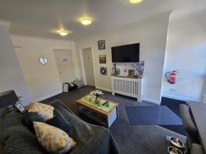 a living room with a couch and a tv at Haybow Farm Accommodation in Rolstone