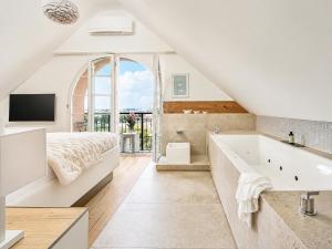 a bedroom with a bed and a tub and a television at Boutique Suites and Residences Heidelberg- Alte Zigarrenmanufaktur in Heidelberg