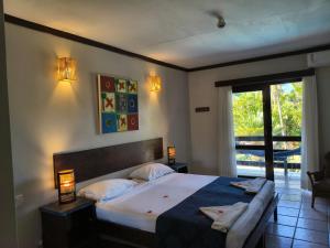 a bedroom with a large bed and a window at Porto Zarpa Hotel in Praia do Forte +60 photos