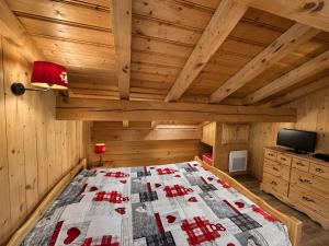 a bedroom with a bed in a wooden room at Le Tyrol in La Plagne Tarentaise