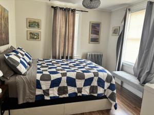 a bedroom with a bed with a blue and white comforter at The Bushnell Suite C2 in Hartford