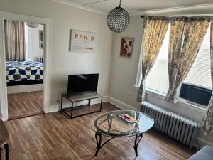 a living room with a table and a tv at The Bushnell Suite C2 in Hartford