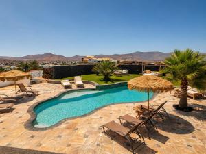 a swimming pool with chairs and umbrellas at Exceptional Villa With Pool in Villaverde