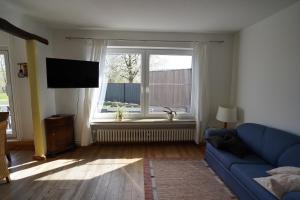 a living room with a blue couch and a window at Ferienhaus Weserblick in Rinteln