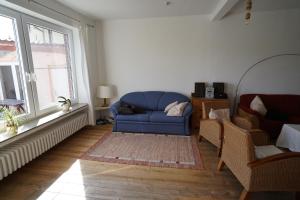 a living room with a blue couch and two windows at Ferienhaus Weserblick in Rinteln +38 photos