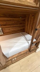 a bed in a small room with wooden walls at Marevita Hostel in Alicante