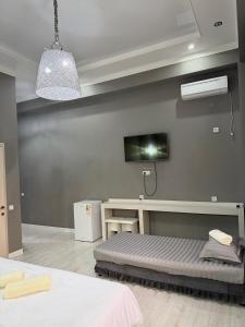 a bedroom with a bed and a tv on the wall at Nogai Karavan in Türkistan +10 photos