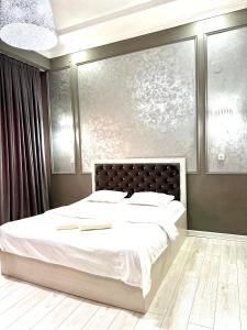 a bedroom with a large bed with white sheets at Nogai Karavan in Türkistan