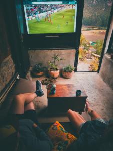 a person watching a soccer game on a television at Wolf Totem Steam Punk Guesthouse in Pisac