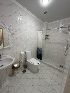 a bathroom with a toilet and a sink and a shower at Nogai Karavan in Türkistan