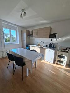 a kitchen with a table and chairs in a room at Aux Ogiers in Croix