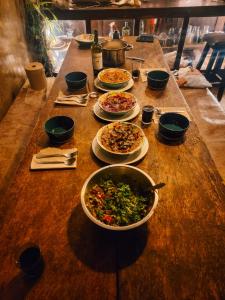 a table topped with plates of food and bowls of food at Wolf Totem Steam Punk Guesthouse in Pisac