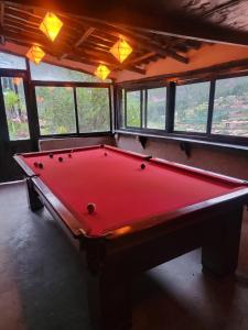 a red pool table in a room with windows at Wolf Totem Steam Punk Guesthouse in Pisac +98 photos