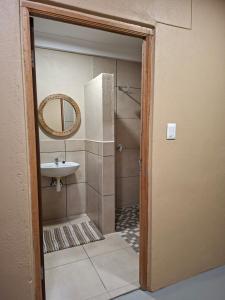 a bathroom with a sink and a mirror at Pi-Buddy Lodge and Bushcamp in Outjo
