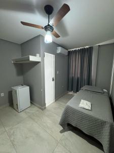 a bedroom with a bed and a ceiling fan at Neves Hotel II in Ipatinga