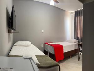 a hospital room with two beds and a desk at Neves Hotel II in Ipatinga