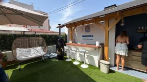 a woman standing next to a food stand in a backyard at Marevita Hostel in Alicante
