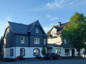 a black and white house with a car parked in front at Maries bunte Villa in Bad Berleburg