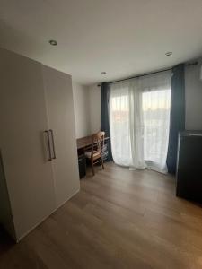 an empty room with a desk and a window at Deluxe family room in Chessington